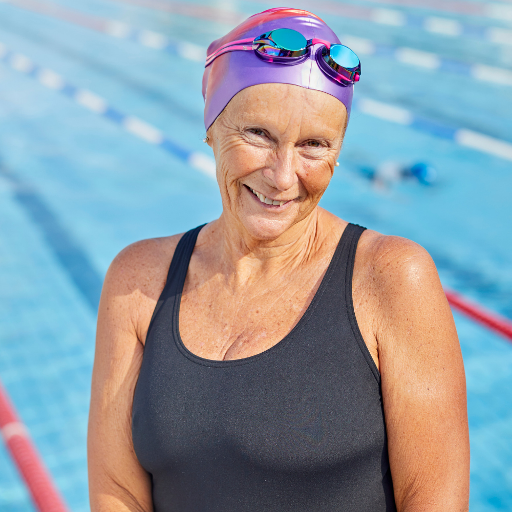 Senior woman smiling in front of swimming pool