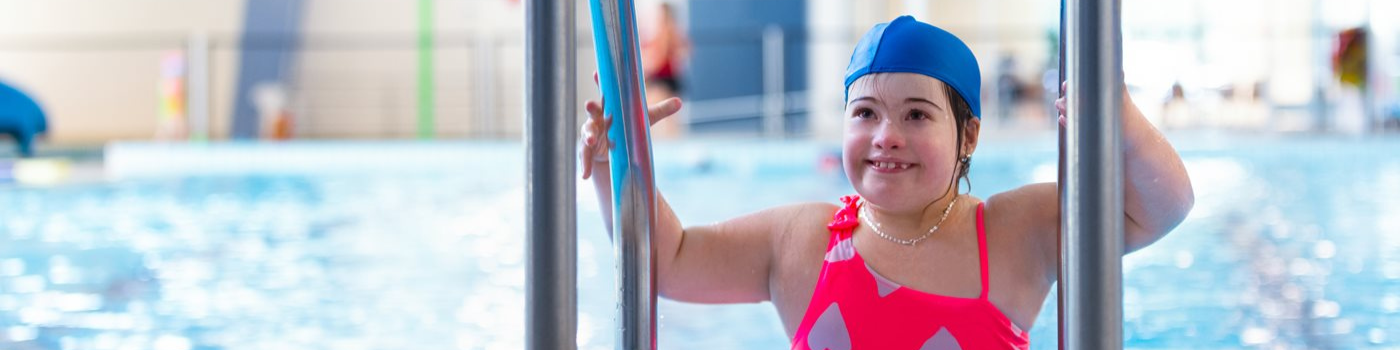 Child and swim teacher in swimming pool