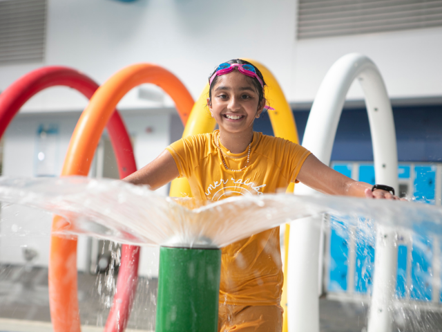 Young girl in children's leisure pool with splash features