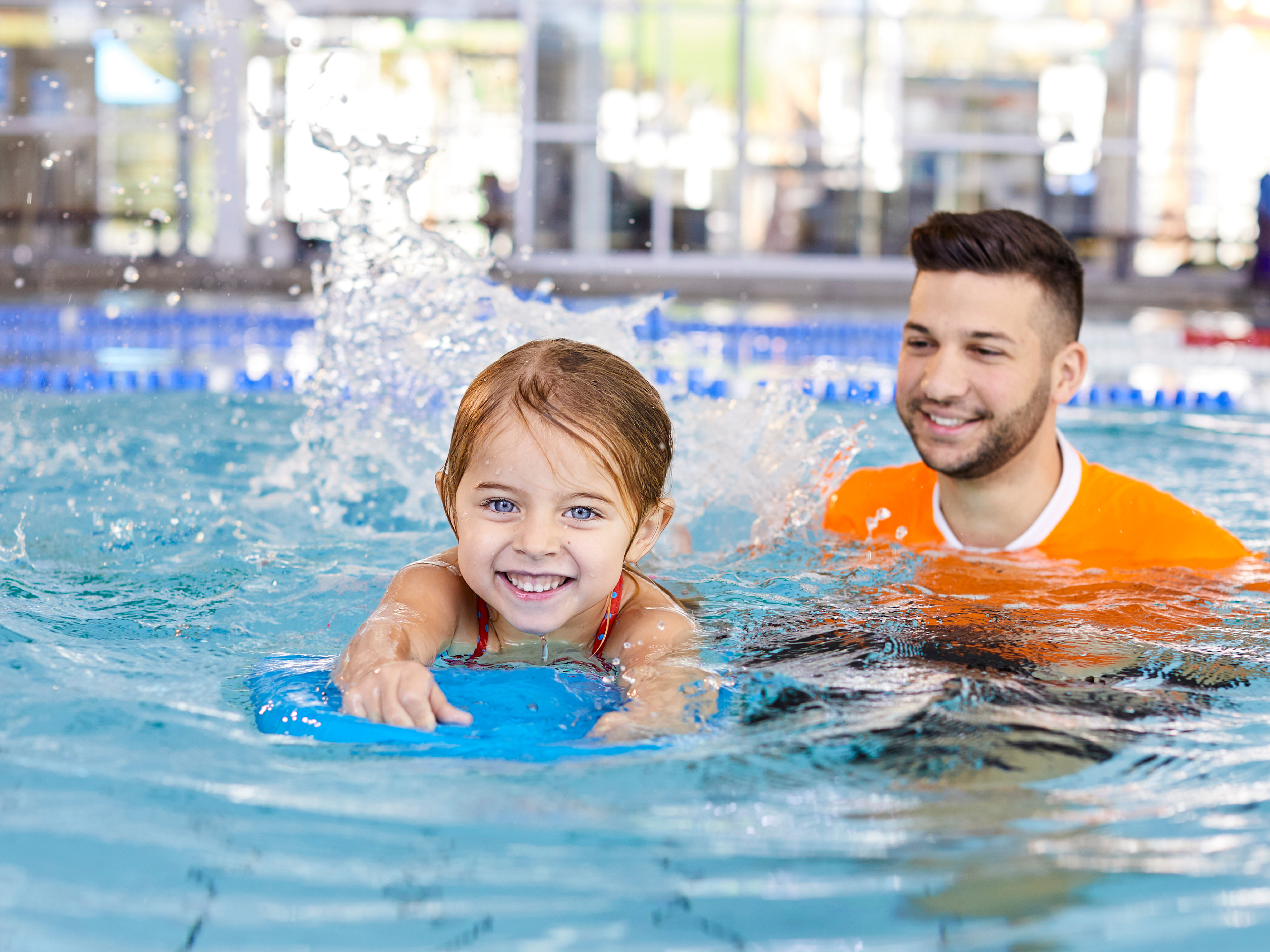 Child and swim teacher in swimming pool