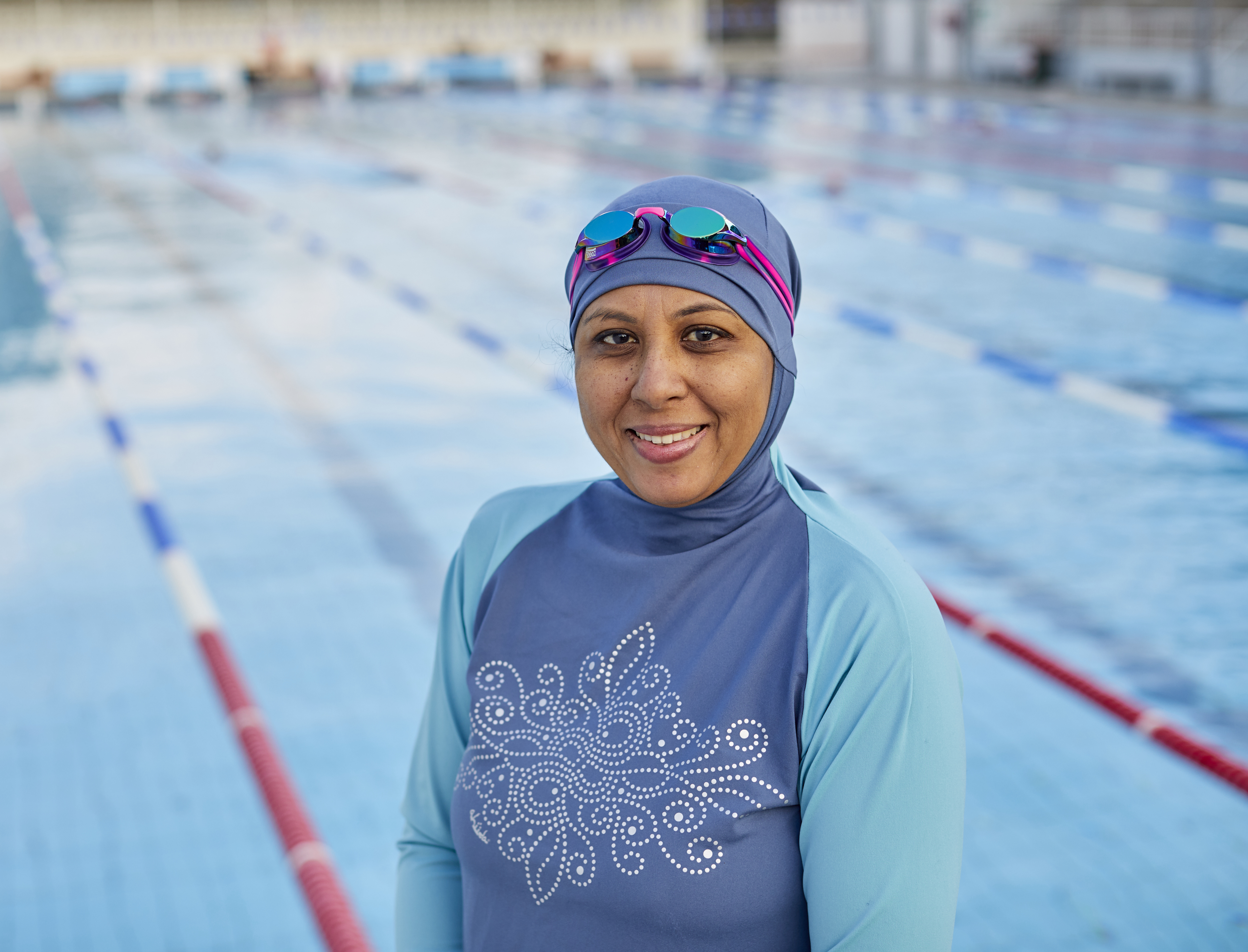 Woman in front of swimming pool wearing conservative swimwear