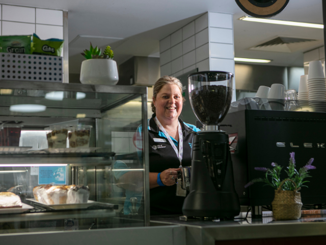 TRAC cafe and female staff member making coffee